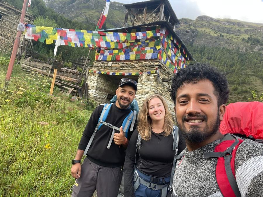 Trekkers at a prayer-flag draped stone kani, Langtang Valley Trek in Nepal